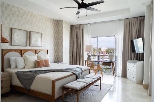 1 dormitorio con 1 cama con ventilador de techo y mesa en Condominio de lujo en Cap Cana Marina!, en Punta Cana