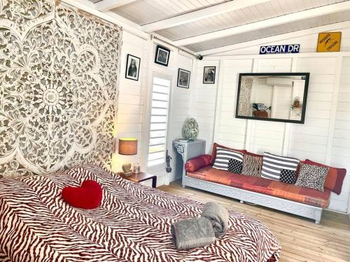 una camera da letto con un letto e una panca in una stanza di Ti kazakat a Le Gosier