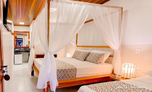 a bedroom with two beds and a canopy bed at Hotel Jeri in Jericoacoara