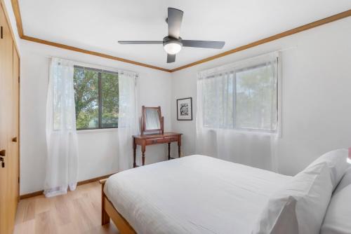 a white bedroom with a bed and a window at Blue House Surf Shack - Pet Friendly in Lennox Head