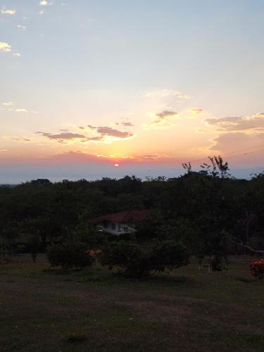 a house in a field with the sunset in the background at Finca Bellavista in Ginebra