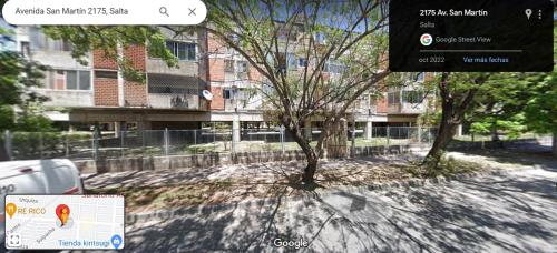 - une vue sur un bâtiment avec des arbres et un panneau dans l'établissement Departamentos San Martin 2175, à Salta