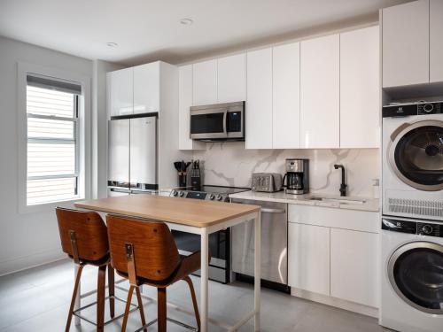 a kitchen with a wooden table and two chairs at Three Bedroom Brooklynite Condo-Hotel Suite! in Brooklyn