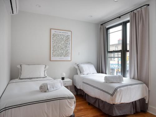 two beds in a room with a window at Three Bedroom Brooklynite Suite! in Brooklyn