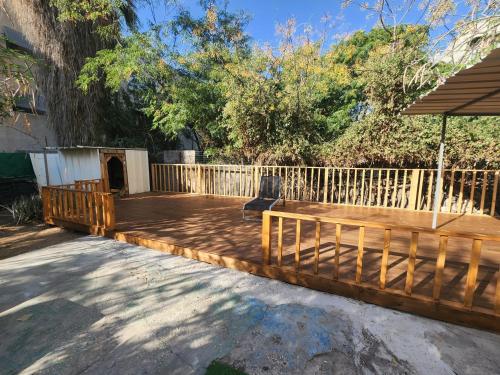 eine Holzterrasse mit einem Sonnenschirm im Hof in der Unterkunft בית מקסים בלב העיר in Tel Aviv