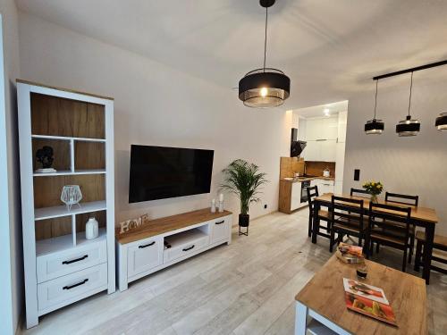 a living room with a television and a dining room at Ottimo Apartamenty Jagiellońska in Bydgoszcz