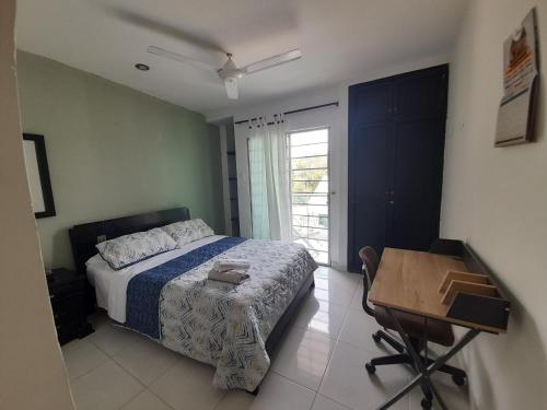 a bedroom with a bed and a desk and a window at Acogedor apartamento Malala's in Sincelejo