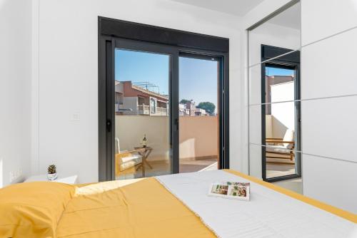 Un dormitorio con una cama y puertas corredizas de vidrio. en Santiago Sunny Seaview Apartment, en Santiago de la Ribera