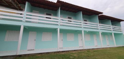 a blue building with white doors and windows at Vila Mar Flats - 1 Dorm - Guriri - 800m da Praia in Guriri