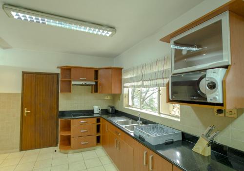 a kitchen with a sink and a microwave at Mimosa Court Apartments in Nairobi