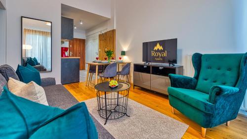 salon z niebieskimi krzesłami i telewizorem w obiekcie Apartamenty Karpatia Resort by ROYAL APARTS w mieście Karpacz