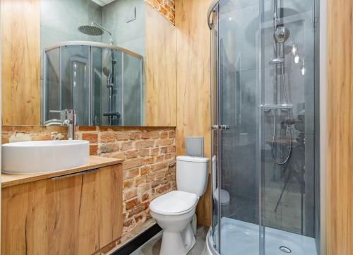 y baño con ducha, aseo y lavamanos. en Golden Apartment Piotrkowska 116 en Lodz