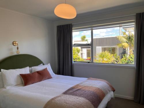 a bedroom with a bed and a large window at Townhouse on Courtenay in New Plymouth