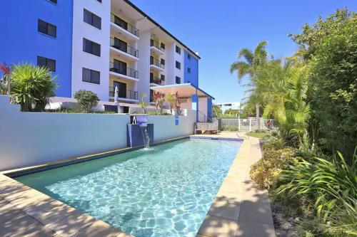 a swimming pool in front of a building at Ocean Breeze 3BR Apartment in Bargara
