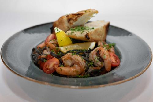 a plate of food with shrimp and other vegetables at Park Inn by Radisson Oslo Airport Hotel West in Gardermoen