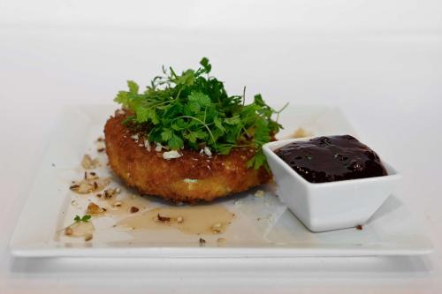 a white plate with a pastry and a bowl of sauce at Park Inn by Radisson Oslo Airport Hotel West in Gardermoen