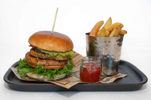 a hamburger and french fries on a tray with ketchup at Park Inn by Radisson Oslo Airport Hotel West in Gardermoen