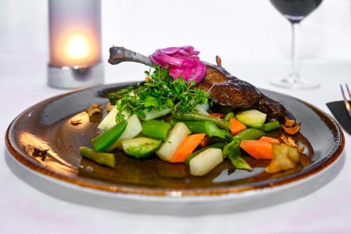 a plate of food with vegetables on a table at Park Inn by Radisson Oslo Airport Hotel West in Gardermoen