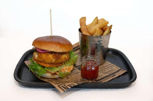 a tray with a hamburger and french fries and ketchup at Park Inn by Radisson Oslo Airport Hotel West in Gardermoen