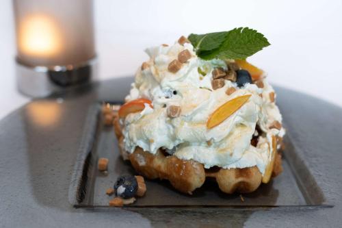 a dessert with whipped cream and fruit on a plate at Park Inn by Radisson Oslo Airport Hotel West in Gardermoen