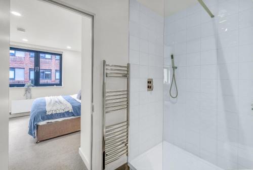 La salle de bains est pourvue d'une douche à l'italienne à côté d'un lit. dans l'établissement Contractors Gem, 2 bed, sleeps 6, bathroom & ensuite, à Bedford