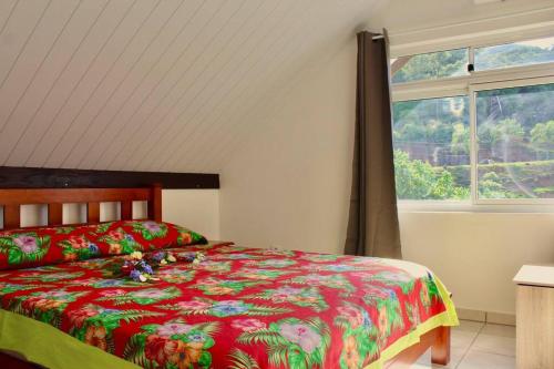 een slaapkamer met een bed en een raam bij Tekauhivai Lodge in Uturoa
