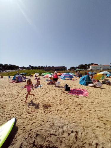 a group of people on a beach with umbrellas at O Mundo da Lua in Azeitao