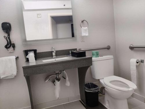 a bathroom with a toilet and a sink with a mirror at Best Western Atlanta Cumberland Galleria Hotel in Atlanta