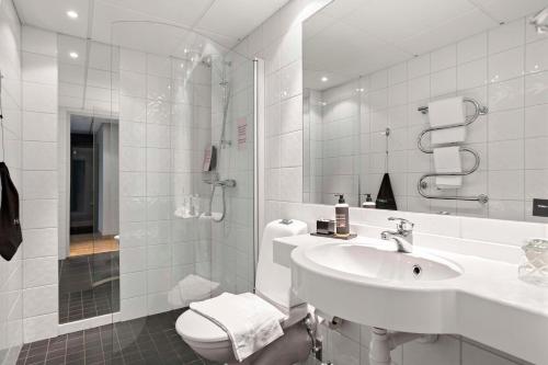 Baño blanco con lavabo y aseo en Aiden by Best Western Stockholm Solna, en Solna