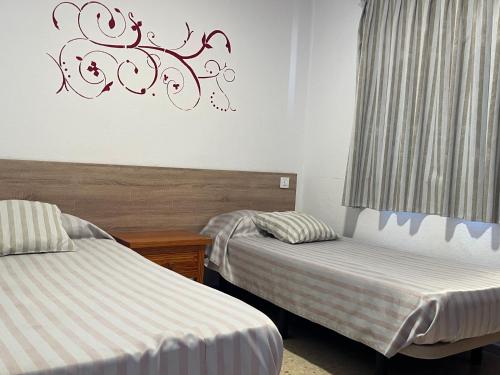1 dormitorio con 2 camas y un cartel en la pared en Apartamentos Buenavista, en Puerto Rico de Gran Canaria