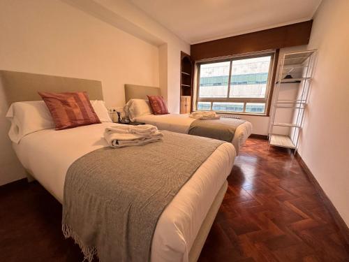 1 dormitorio con 2 camas y ventana en Oktheway Big Coruña, en A Coruña