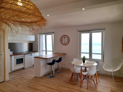 une cuisine et une salle à manger avec une table et des chaises dans l'établissement L'appartement LA PLAGE, à Le Portel