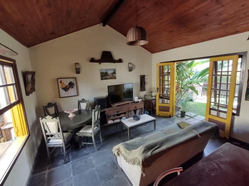 ein Wohnzimmer mit einem Sofa und einem Tisch in der Unterkunft Casa Peró Cabo Frio 2 suítes em Condomínio in Cabo Frio