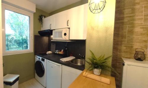 a small kitchen with a sink and a microwave at Les Elfes - avec entrée autonome, jardin, parking privé & gourmandises offertes ! - in Toulouse