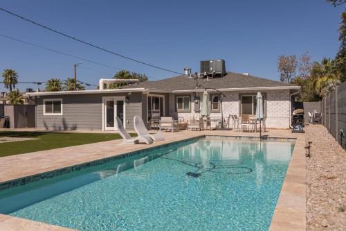 a house with a swimming pool in front of a house at Modern Arcadia Lite Oasis Pool Heater BBQ in Phoenix