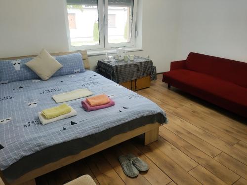 1 dormitorio con 1 cama y 1 sofá rojo en Family Hotel Provide breakfast, en Subotica