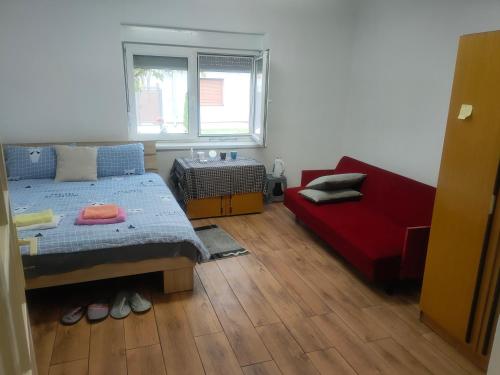 1 dormitorio con 1 cama y 1 sofá rojo en Family Hotel Provide breakfast, en Subotica