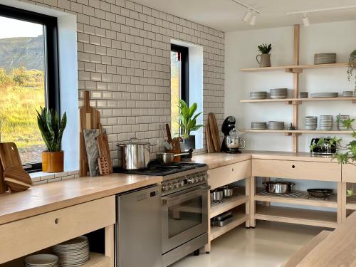 a kitchen with a stove and a counter top at The Oceanfront Private Northern Lights Villa in Reynivellir