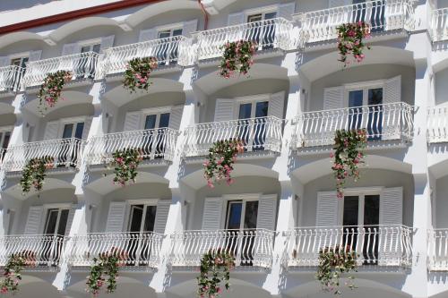 eine Fassade eines Hotels mit weißen Balkonen und Blumen in der Unterkunft Minori Palace in Minori