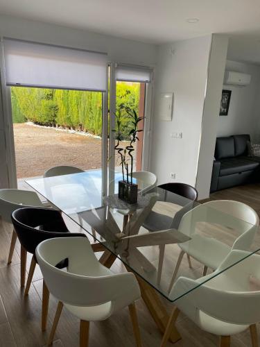 a dining room with a glass table and chairs at Villa Castro in Nuévalos