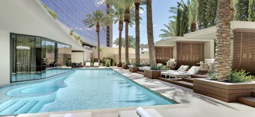 a swimming pool with palm trees and a building at Red Rock Casino Resort & Spa in Las Vegas