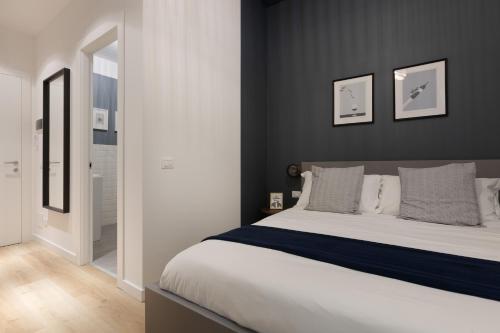 a bedroom with a large bed with two pictures on the wall at Central Trieste Marvel studio in Trieste