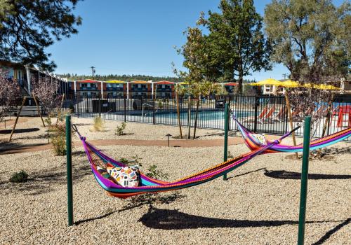 a colorful hammock in a park with a playground at Americana Motor Hotel in Flagstaff