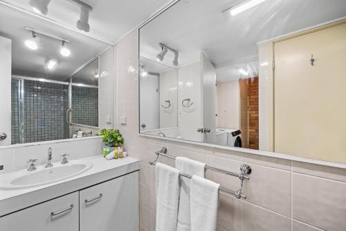 a bathroom with a sink and a mirror at Avalon on Alex Beach 2 Bedroom Apartment in Alexandra Headland