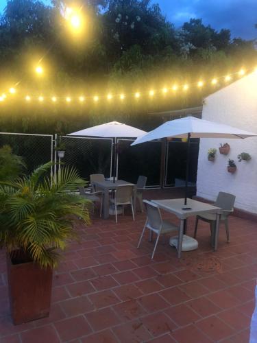 a patio with tables and umbrellas at night at Espectacular Casa Campestre Frente al Río Fonce in San Gil