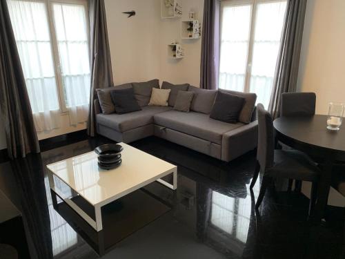 un salon avec un canapé et une table dans l'établissement Thao, à Serris