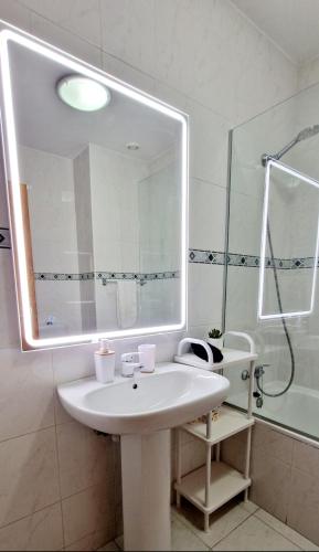 a bathroom with a white sink and a mirror at Ocean Pearl Apartment K in Funchal