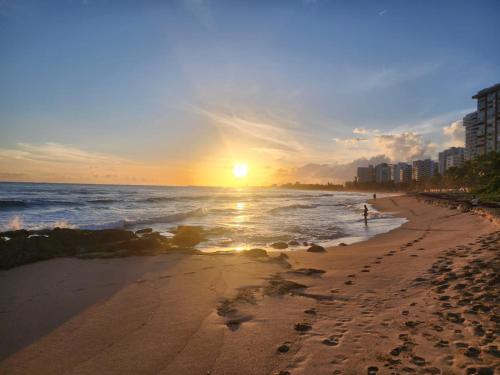 a person walking on the beach at sunset at Gorgeous 1-Bedroom Beachside Suite in San Juan