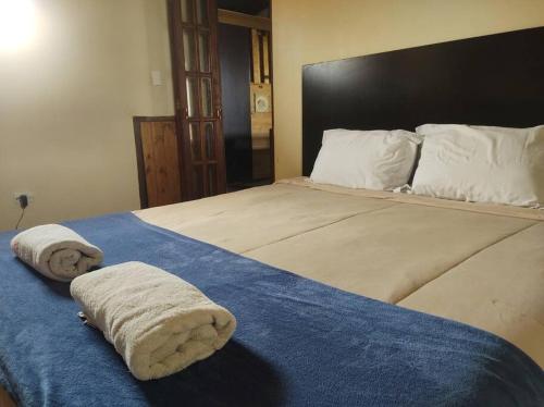 a bedroom with a large bed with towels on it at Hospedagem San Gonzales in Sorocaba