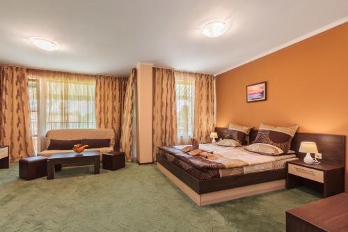 a bedroom with a large bed and a couch at Villa Brigantina in Sunny Beach